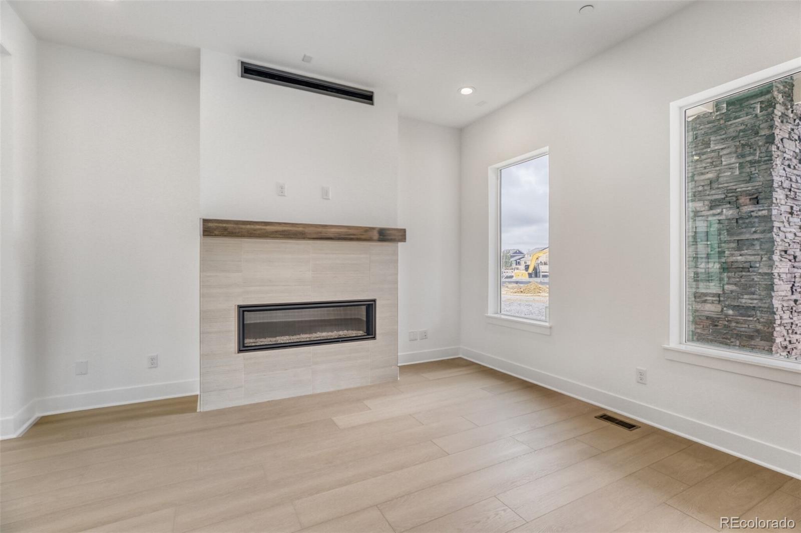 672 Apex Street Erie, CO 80516 - Photo 2 of 19 an empty room with windows and fireplace