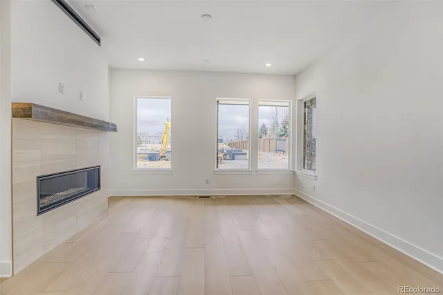 an empty room with windows and fireplace