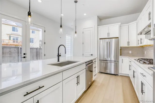 a kitchen with white cabinets and stainless steel appliances