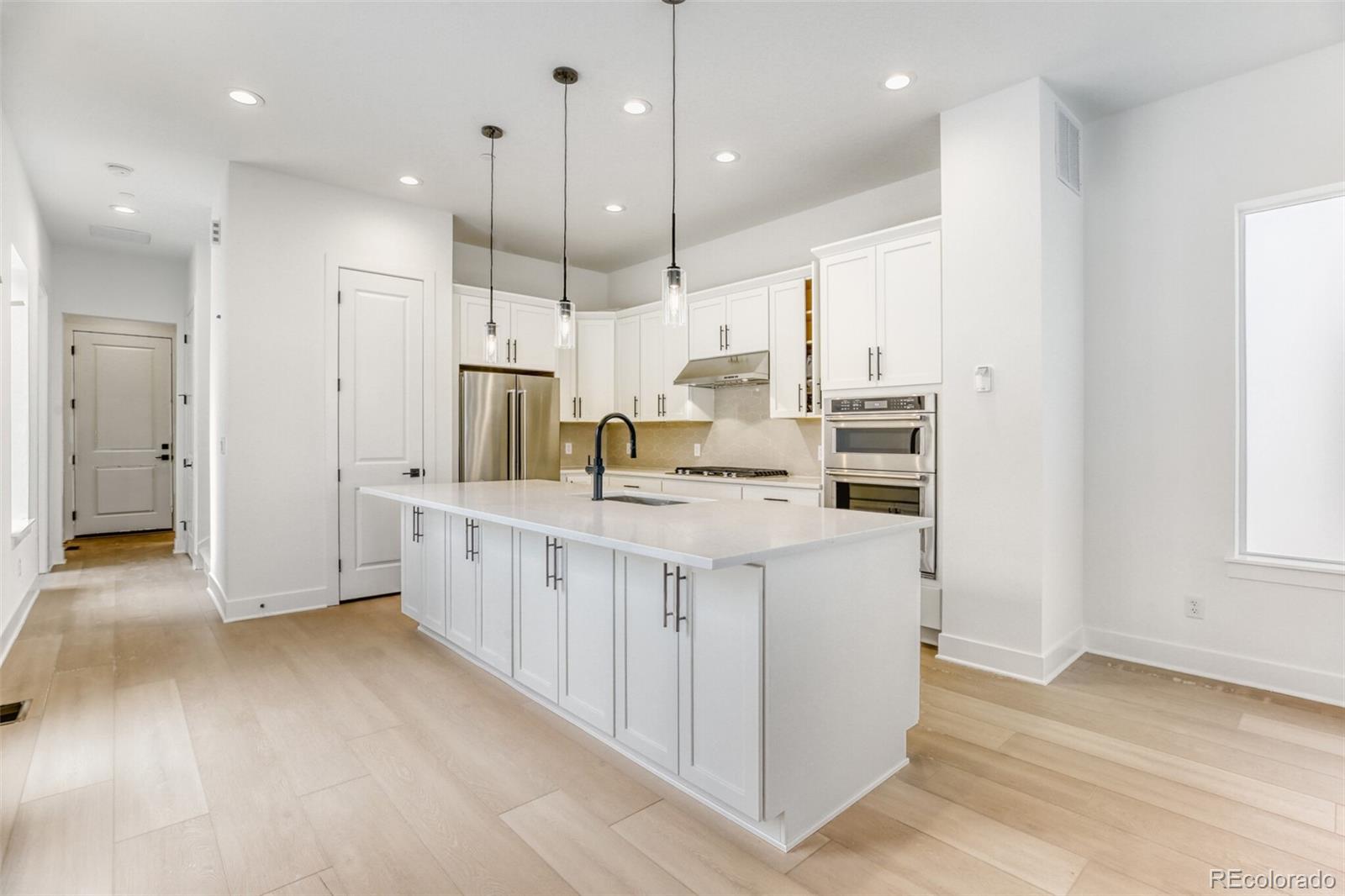 672 Apex Street Erie, CO 80516 - Photo 5 of 19 a large kitchen with a large counter top appliances and cabinets