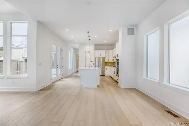 a view of a big room with wooden floor and windows