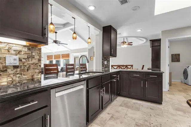 a kitchen with stainless steel appliances granite countertop a sink and wooden cabinets
