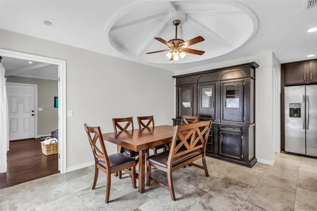 a dining room with furniture and chandelier fan