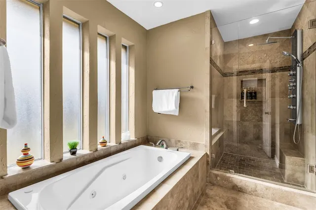 a bathroom with a tub a sink and a large mirror