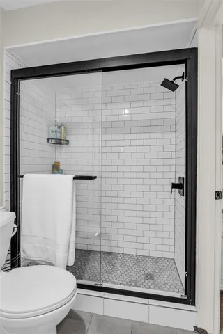 a bathroom with a shower a toilet and a sink