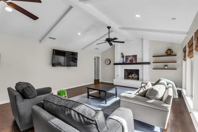 a living room with furniture a flat screen tv and a fireplace