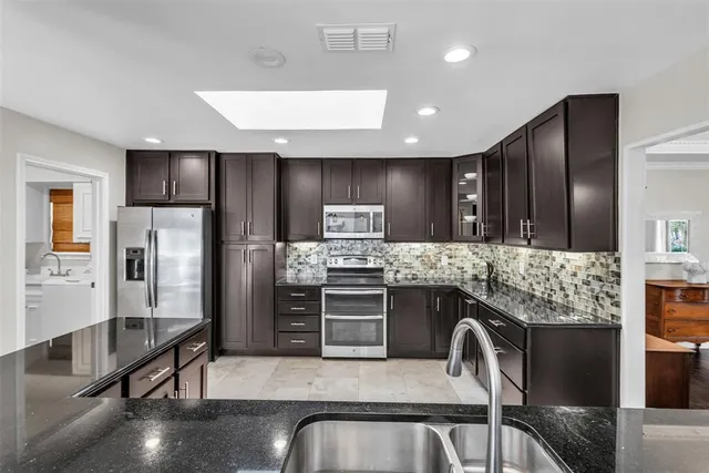 a kitchen with stainless steel appliances granite countertop a refrigerator and a stove