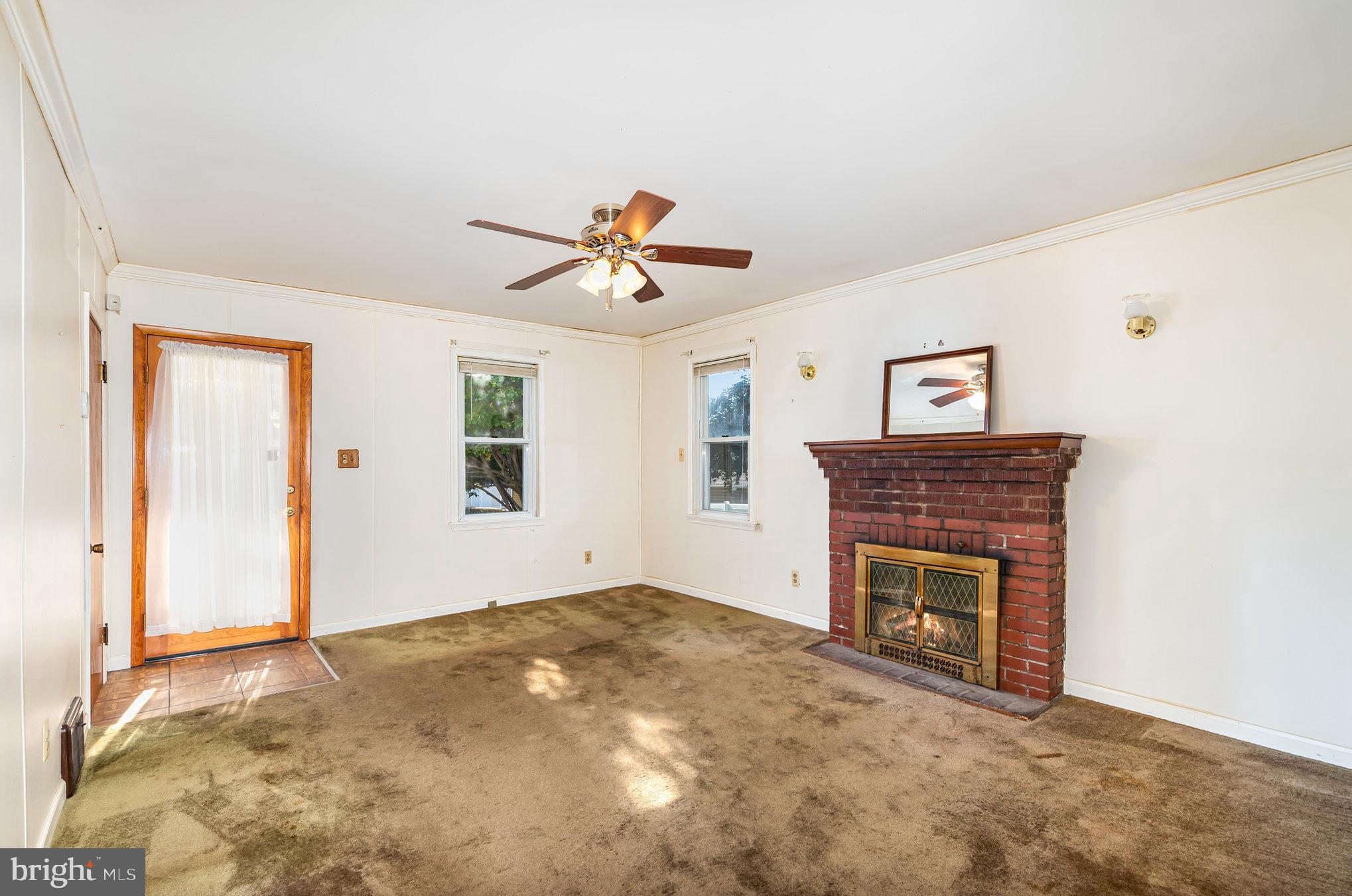 1940 Robinwood Road Baltimore, MD 21222 - Photo 6 of 36 an empty room with windows and fireplace