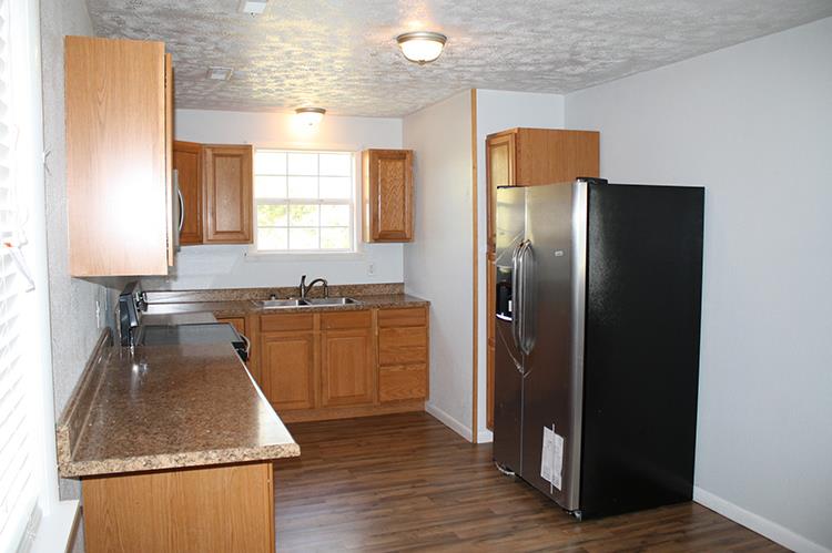 267 Raintree Drive Clarksville, TN 37042 - Photo 1 of 10 a kitchen with wooden cabinets and refrigerator