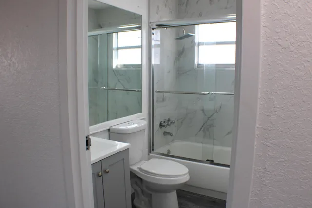 a bathroom with a sink toilet and shower