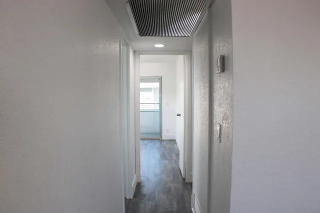 a view of a hallway with wooden floor