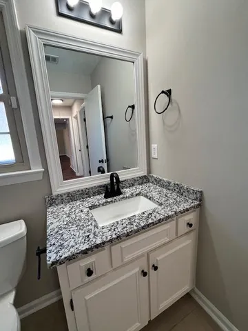 a bathroom with a granite countertop sink and a mirror