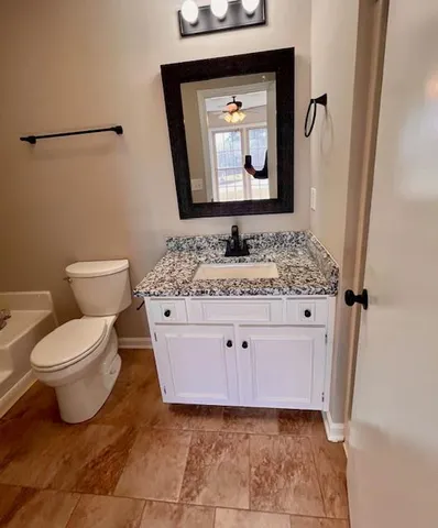 a bathroom with a toilet sink and mirror