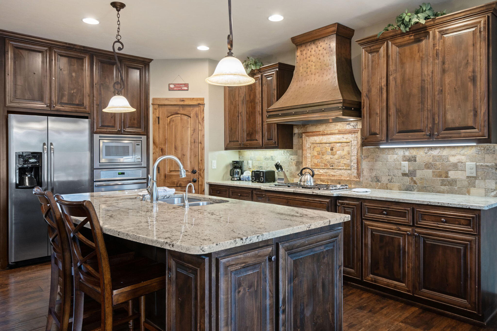 56508 Dancing Rock Loop, Unit 22 Bend, OR 97707 - Photo 18 of 69 a kitchen with kitchen island granite countertop wooden cabinets and a refrigerator