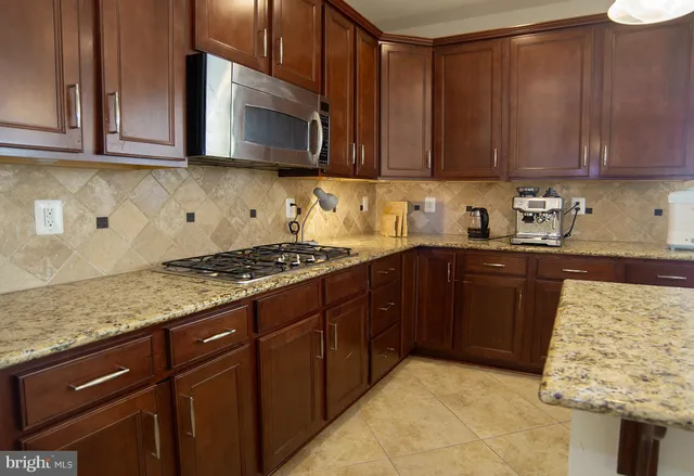a kitchen with stainless steel appliances granite countertop a sink and a refrigerator