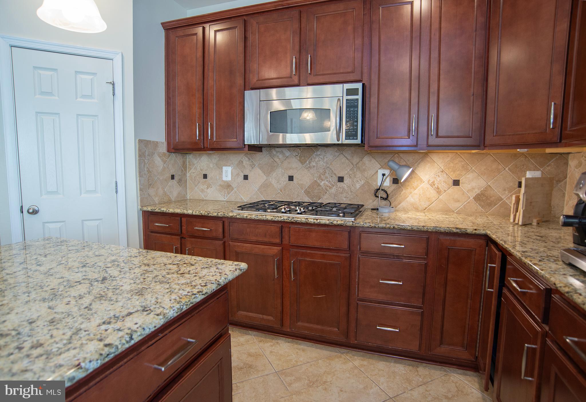 20 Aster Lane Stafford, VA 22554 - Photo 13 of 57 a kitchen with granite countertop wooden cabinets stainless steel appliances and a sink