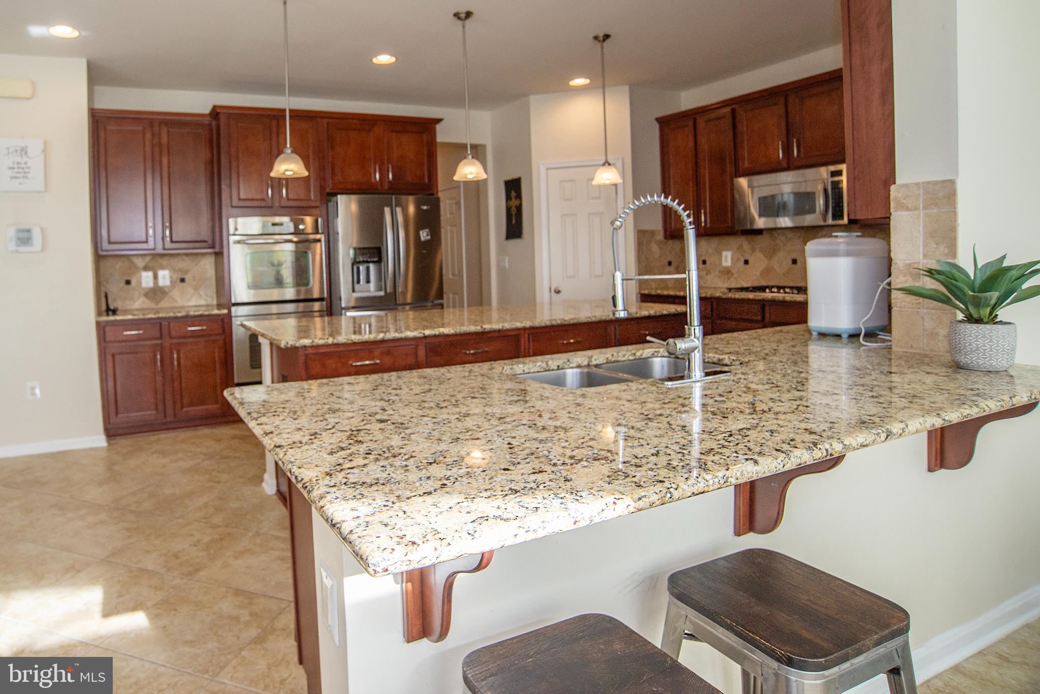 20 Aster Lane Stafford, VA 22554 - Photo 15 of 57 a kitchen with stainless steel appliances granite countertop a sink and a refrigerator