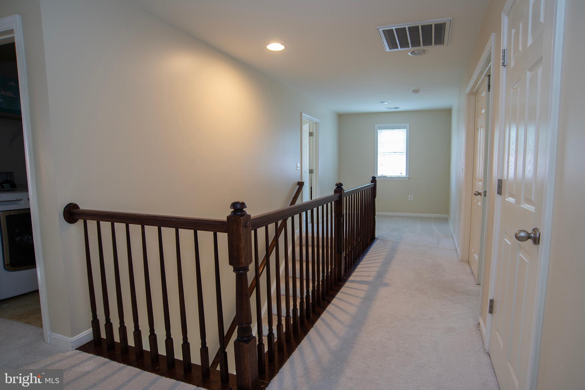 20 Aster Lane Stafford, VA 22554 - Photo 22 of 57 a view of a hallway with wooden floor and stairs