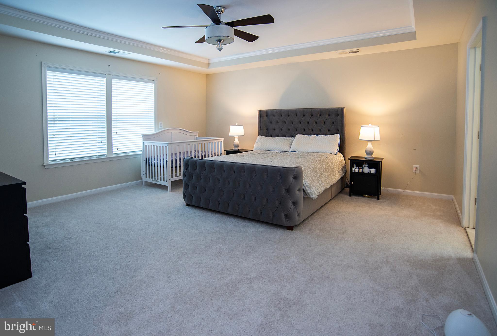 20 Aster Lane Stafford, VA 22554 - Photo 24 of 57 a spacious bedroom with a bed and a chandelier