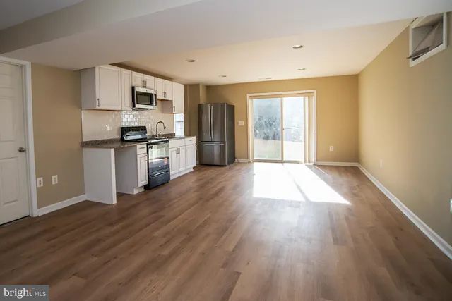 a view of a room with wooden floor and a sink