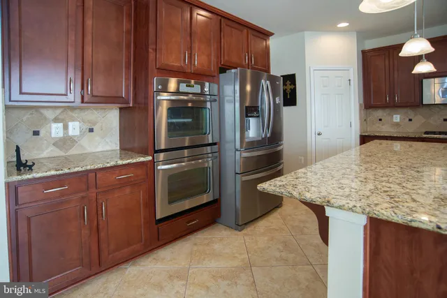 a kitchen with stainless steel appliances granite countertop a sink stove and microwave