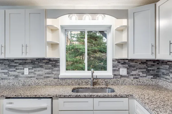 a kitchen with sink a window and cabinets