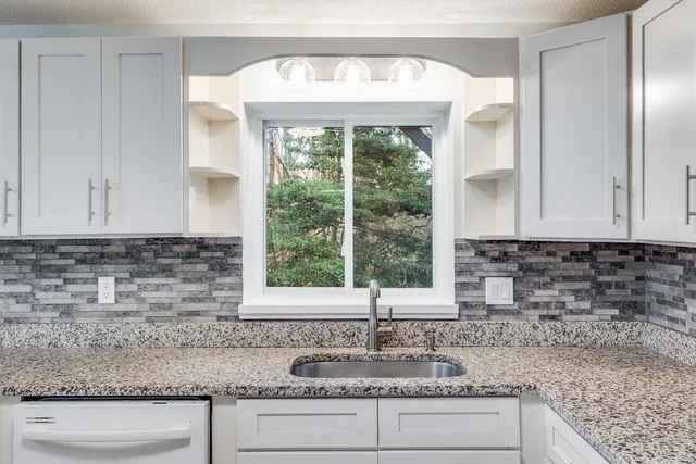 a kitchen with sink a window and cabinets