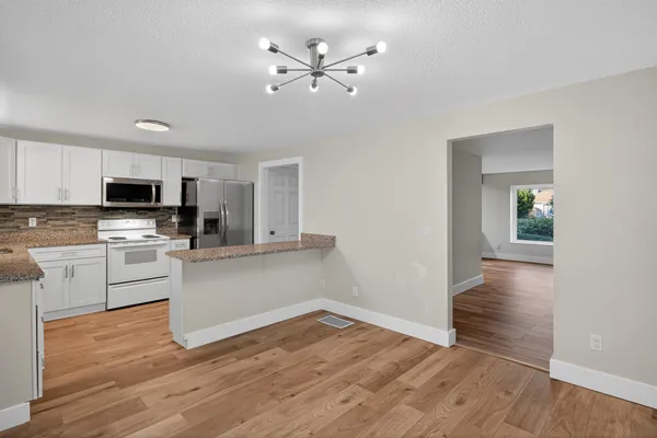 a kitchen with wooden floors and white appliances