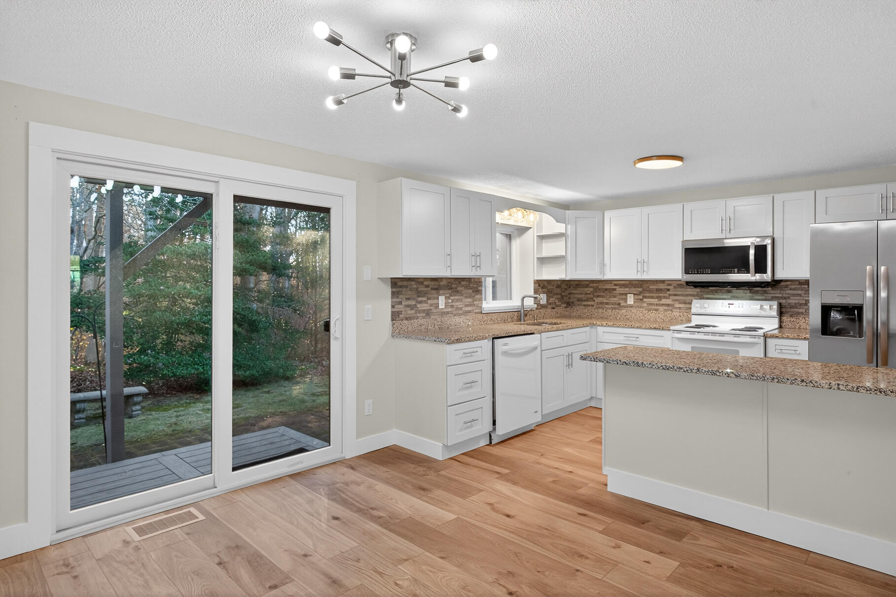 481 Buck Island Road, Unit 11BB West Yarmouth, MA 02673 - Photo 7 of 34 a kitchen with stainless steel appliances granite countertop a stove a sink dishwasher a refrigerator white cabinets and wooden floor