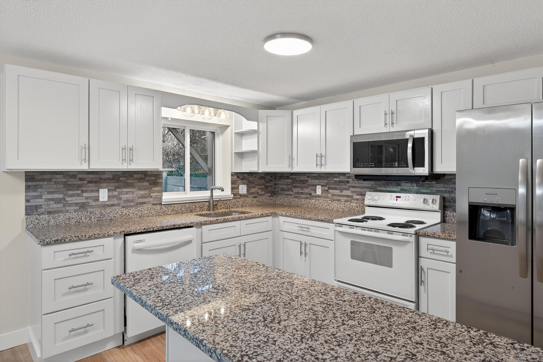 481 Buck Island Road, Unit 11BB West Yarmouth, MA 02673 - Photo 10 of 34 a kitchen with kitchen island granite countertop a stove sink and microwave
