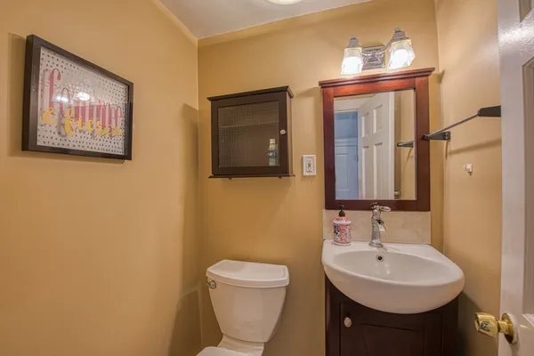 a bathroom with a toilet a sink and mirror