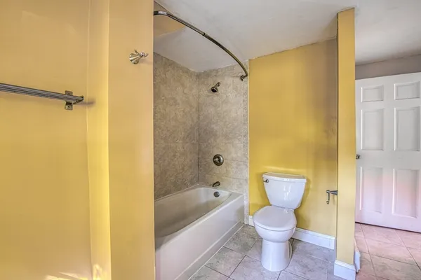 a bathroom with a bathtub shower and toilet