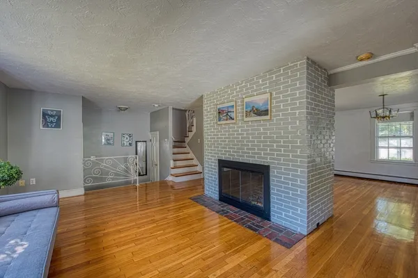 a living room with wooden floor and a fireplace