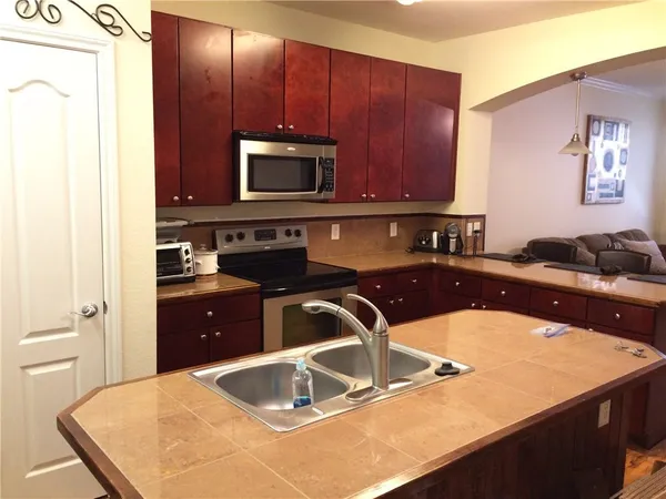 a kitchen with a sink and a stove top oven with wooden floor