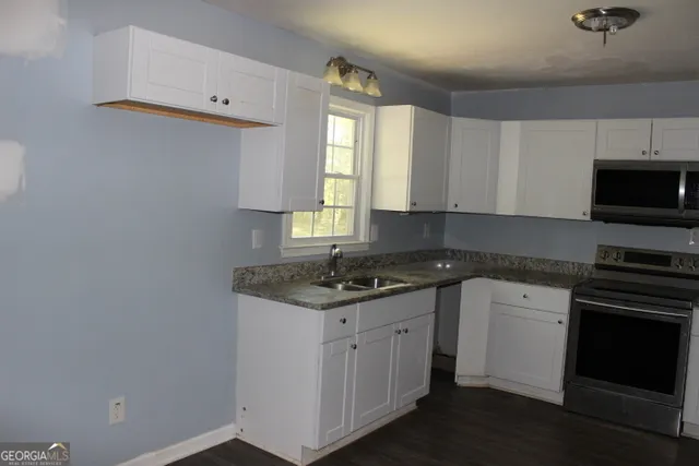 a kitchen with a sink stove and cabinets