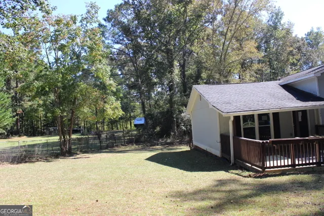 a view of a house with a yard and large tree