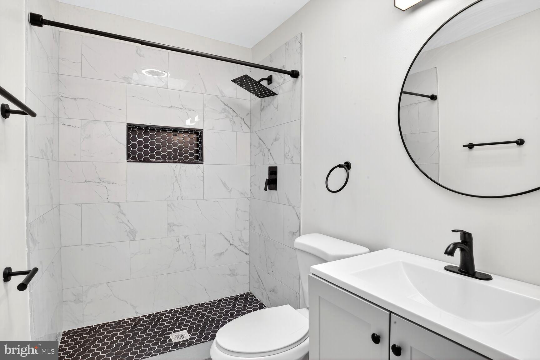 3808 6th Street Baltimore, MD 21225 - Photo 11 of 21 a bathroom with a toilet sink vanity shower and mirror