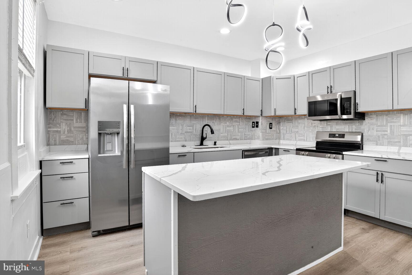 3808 6th Street Baltimore, MD 21225 - Photo 6 of 21 a kitchen with stainless steel appliances a sink stove refrigerator and cabinets