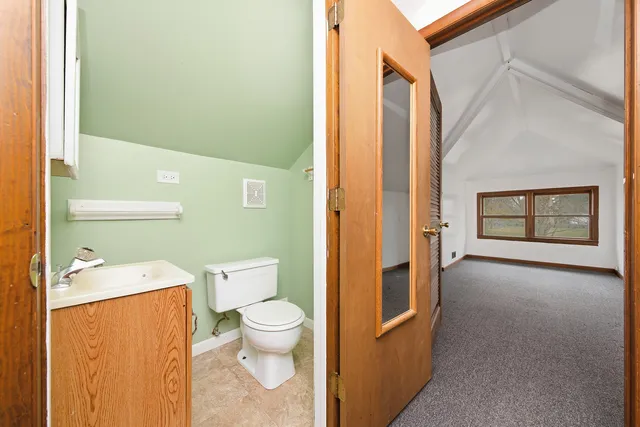 a bathroom with a toilet a sink and a large window