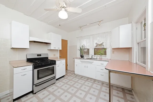 a kitchen with a stove sink and cabinets