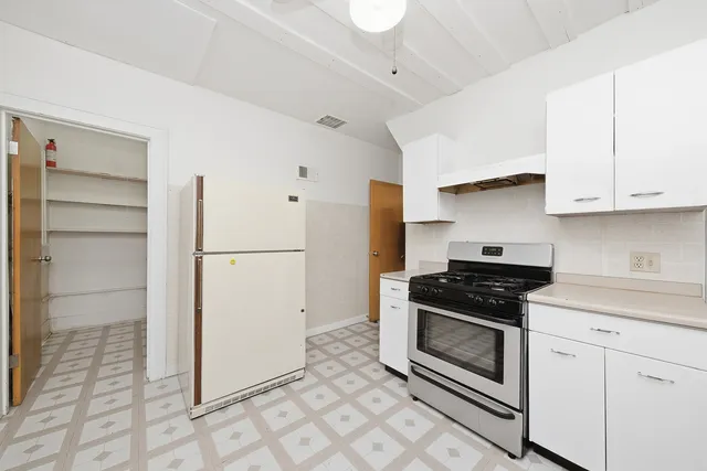 a kitchen with white cabinets and white appliances
