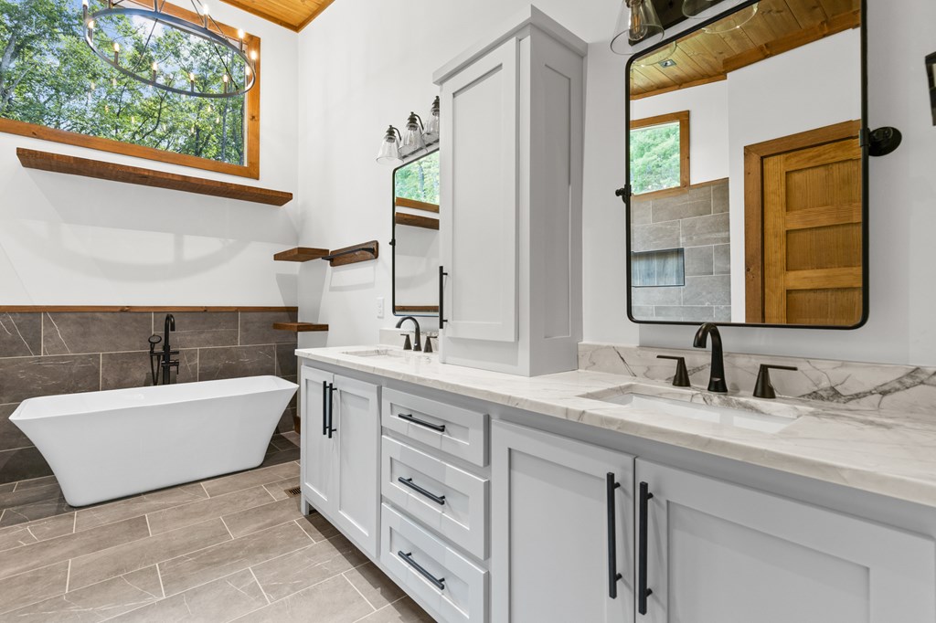 394 Mountain Trace Cherry Log, GA 30522 - Photo 41 of 70 a bathroom with a double vanity sink bathtub and window