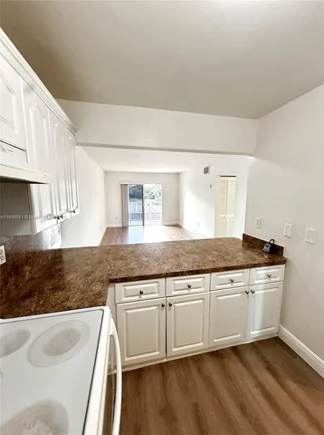 a kitchen with granite countertop white cabinets and a sink