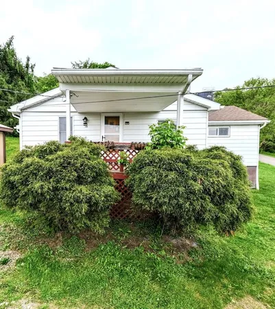 a yellow house with a yard and plants