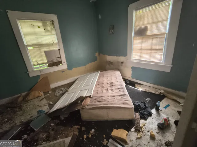 a bed sitting in a bedroom next to a window