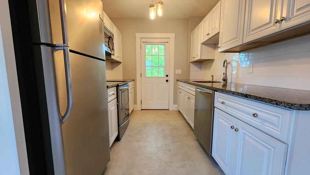 8 Fay Street, Unit 2 Westborough, MA 01581 - Photo 2 of 15 a kitchen with stainless steel appliances granite countertop a refrigerator a sink a stove and cabinets