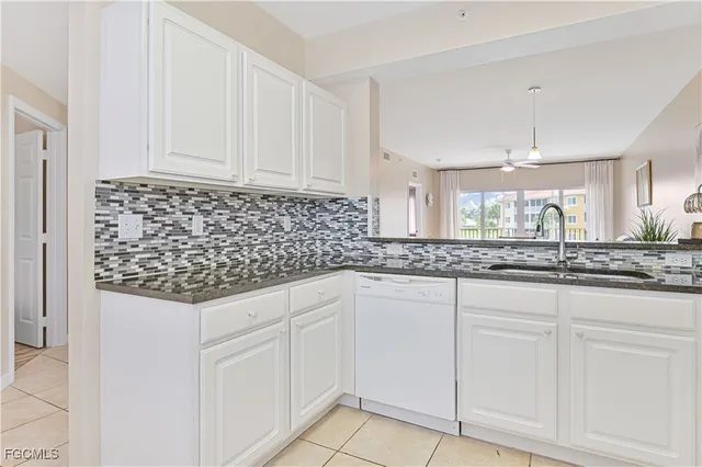 a kitchen with white cabinets and sink