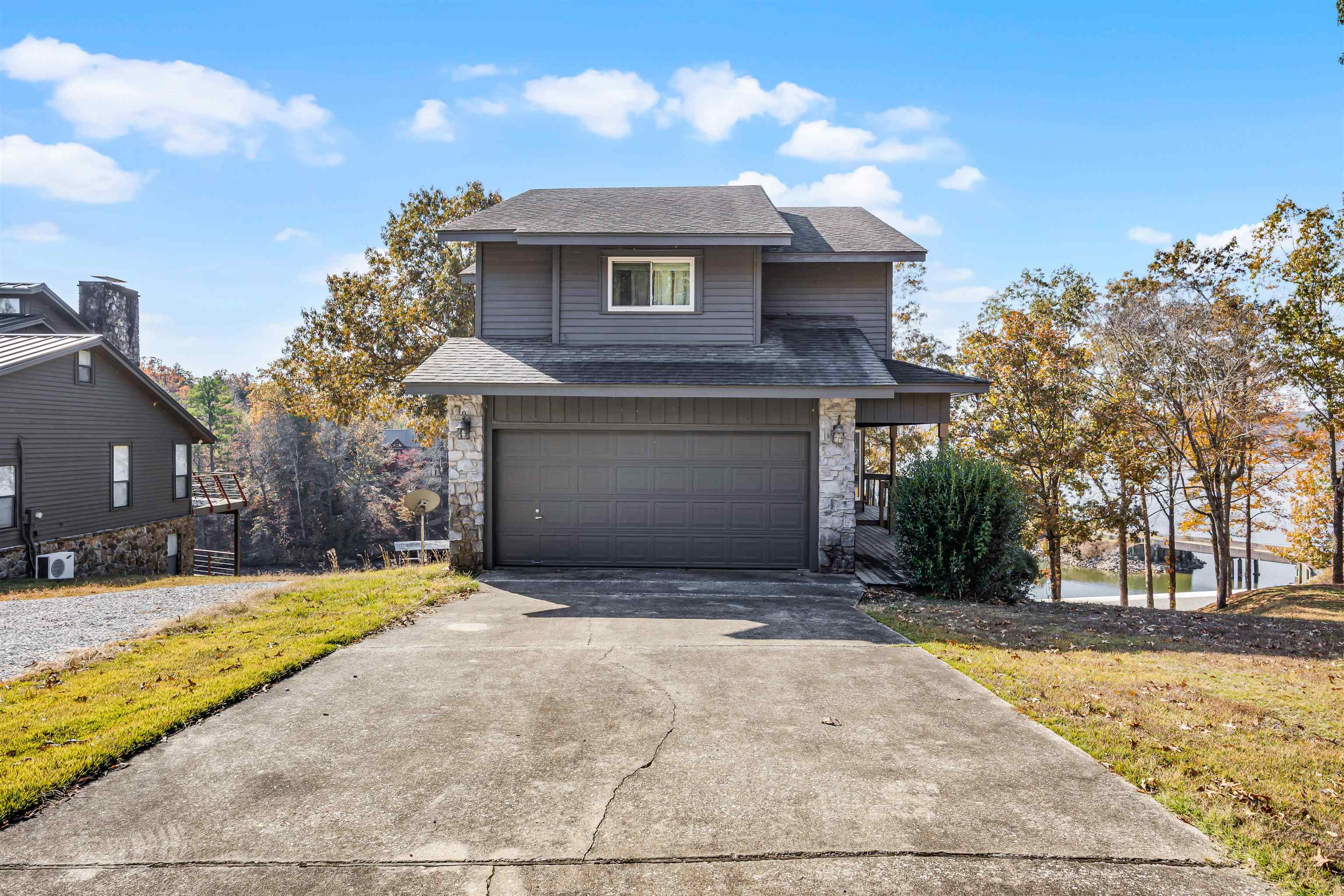 80 Riviera Cove Cherokee, AL 35616 - Photo 25 of 31 Traditional-style home with a shingled roof, a garage, stone siding, driveway, and a water view