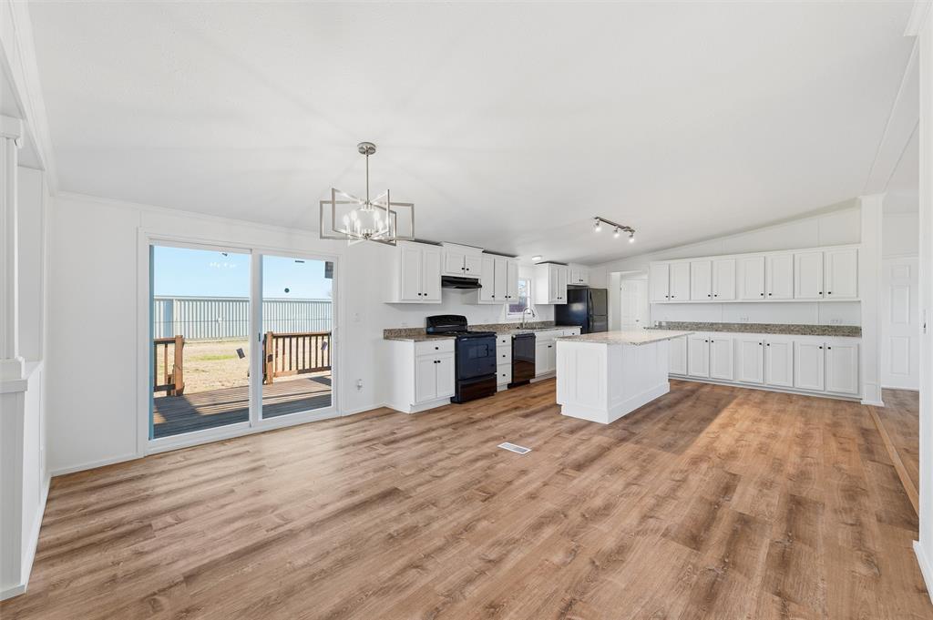 237 Quarterhorse Road Waxahachie, TX 75165 - Photo 12 of 38 a large white kitchen with wooden floors and white cabinets