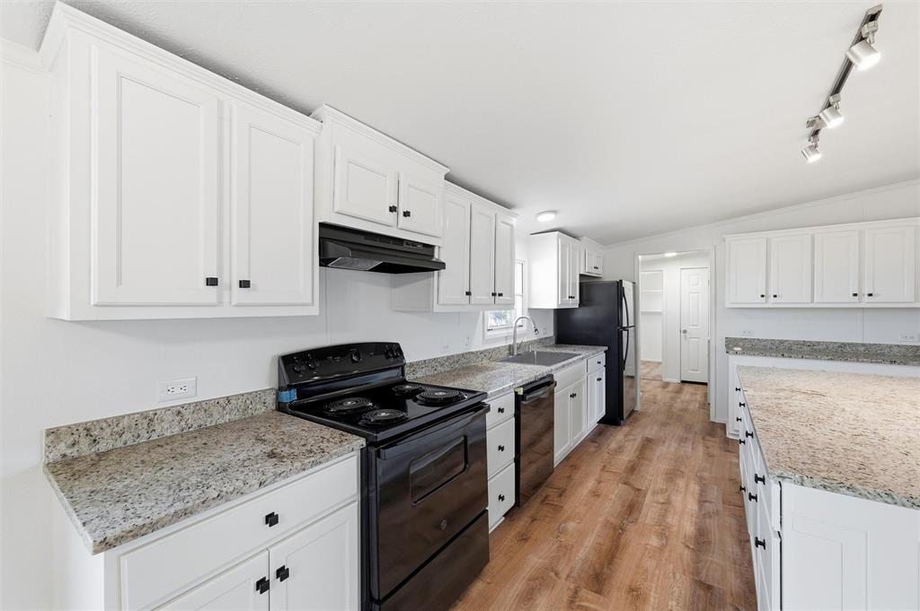 237 Quarterhorse Road Waxahachie, TX 75165 - Photo 16 of 38 a kitchen with granite countertop a stove sink and cabinets